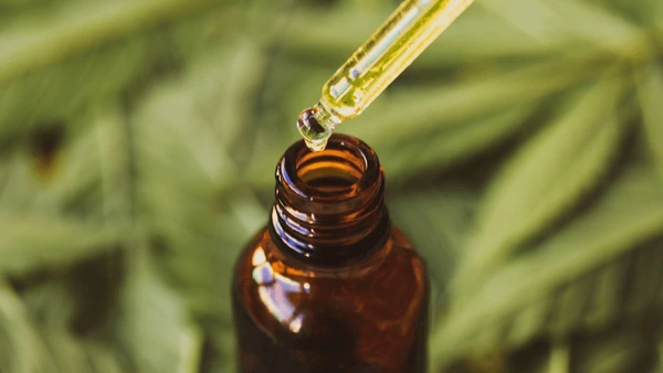 Premium THC Oel Flasche mit Pipette auf dunklem Holzhintergrund